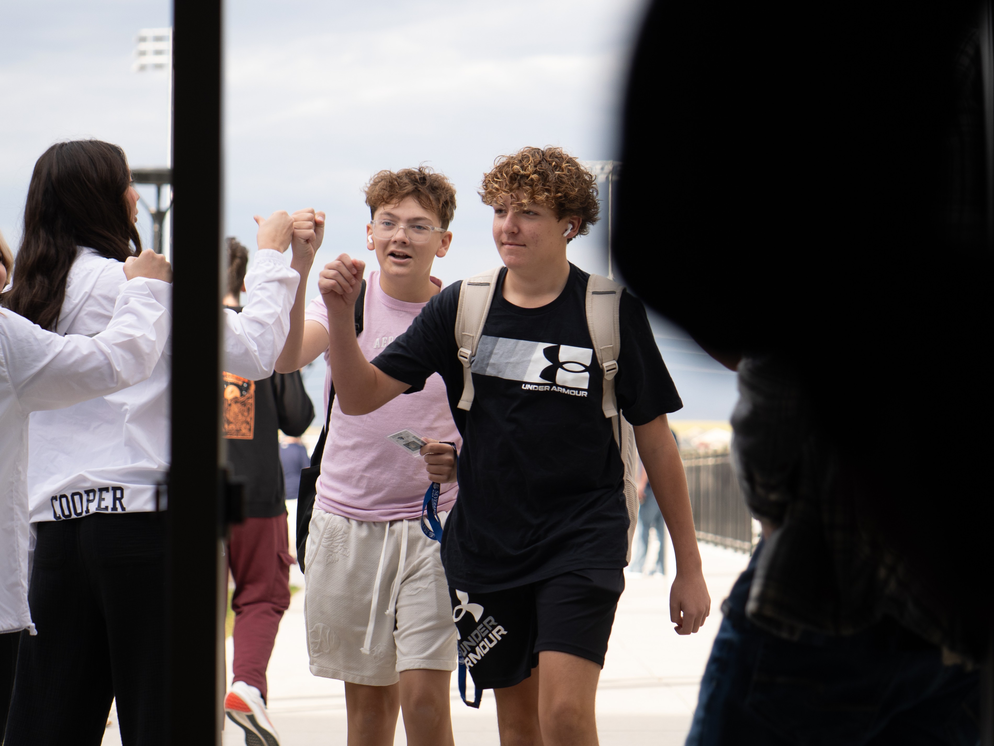 Student enters a building with a fist bump